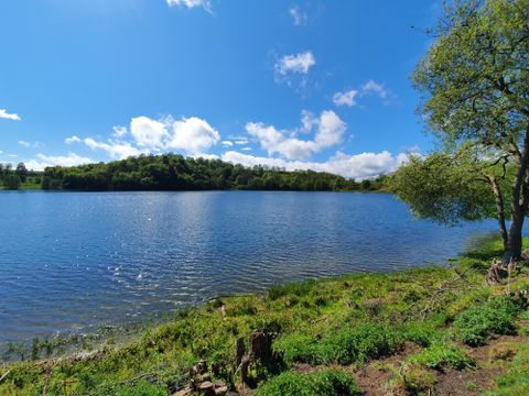 A couple walks hand in hand through a narrow, illuminated rock tunnel. The atmosphere feels adventurous and interesting.