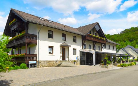 A charming building with multiple floors and balconies. The surroundings are green and invite relaxation.