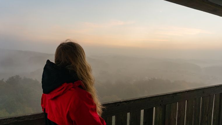 Zonsopgang over mistige heuvels en bebost landschap