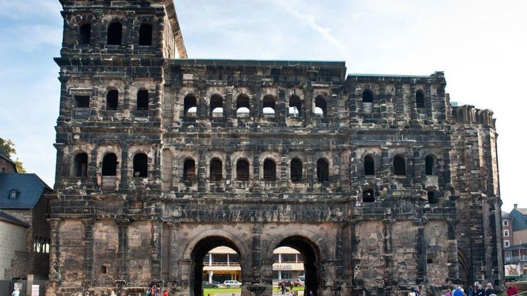 Een historisch gebouw met indrukwekkende architectuur. Veel mensen bezoeken de ruïne.