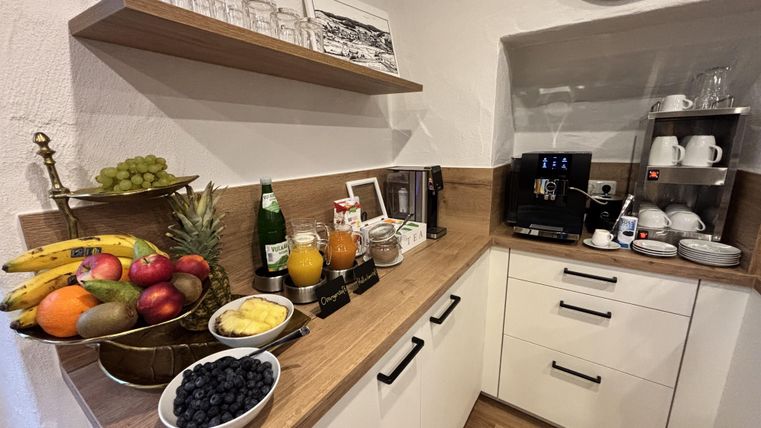 Keukenblok met daarop gerangschikte fruitschaal met koffiemachine en kopjes.