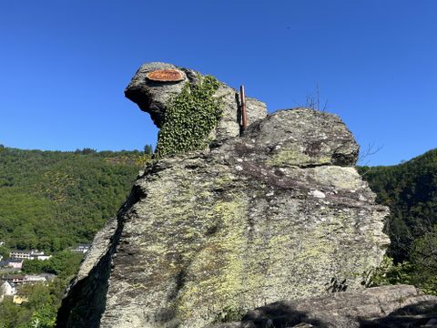 A person is hiking on an uneven, rocky path. They are wearing sturdy hiking shoes and are out in nature.