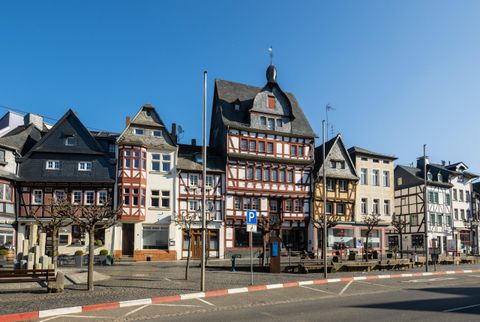 Een schilderachtig oud stadscentrum met historische vakwerkhuizen. De lucht is helder en de straat is rustig.