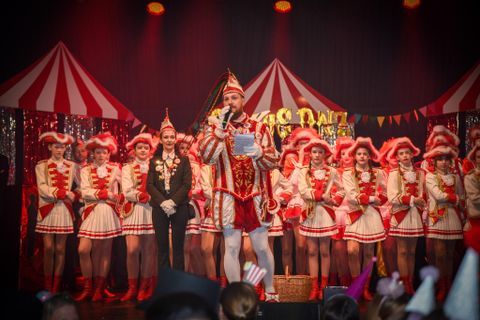 Twee vrouwen in kostuums hebben plezier. De een draagt een politieuniform, de ander een formele outfit.