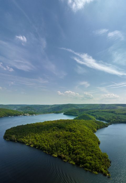 Blick auf einen Stausee und waldige Hügel
