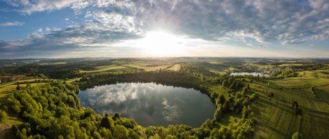Luchtfoto van twee maars in een groen landschap bij zonsondergang.