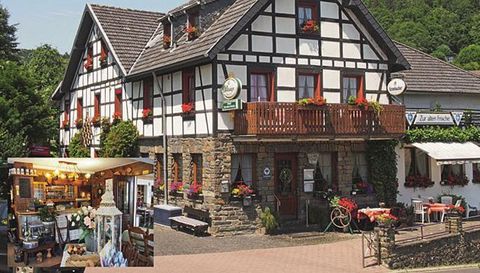 A traditional German inn with a half-timbered style and blooming plants. Inside, a cozy decor can be seen.