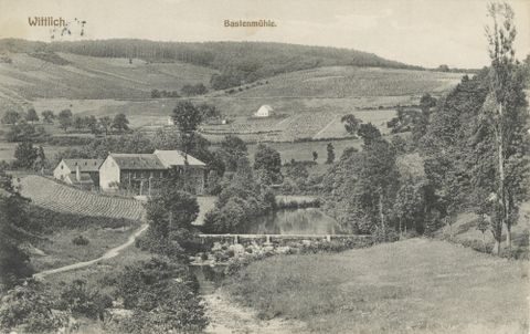 Un paysage idyllique avec des collines douces et une rivière. Au premier plan, des arbres et un bâtiment sont visibles, entourés de champs verts.
