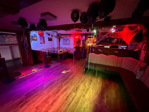 Een feestelijk versierde ruimte met kleurrijke lichten en ballonnen. De zitgedeeltes zijn omringd door een uitnodigende sfeer.