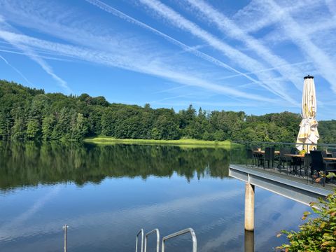 Bitburg reservoir with terrace and parasol on the shore.