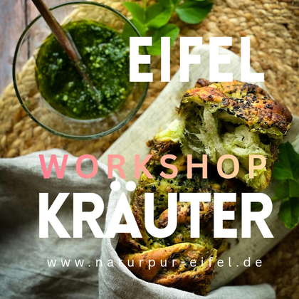 A freshly baked bread with herbs is on a table. Next to it is a glass with green herb sauce.