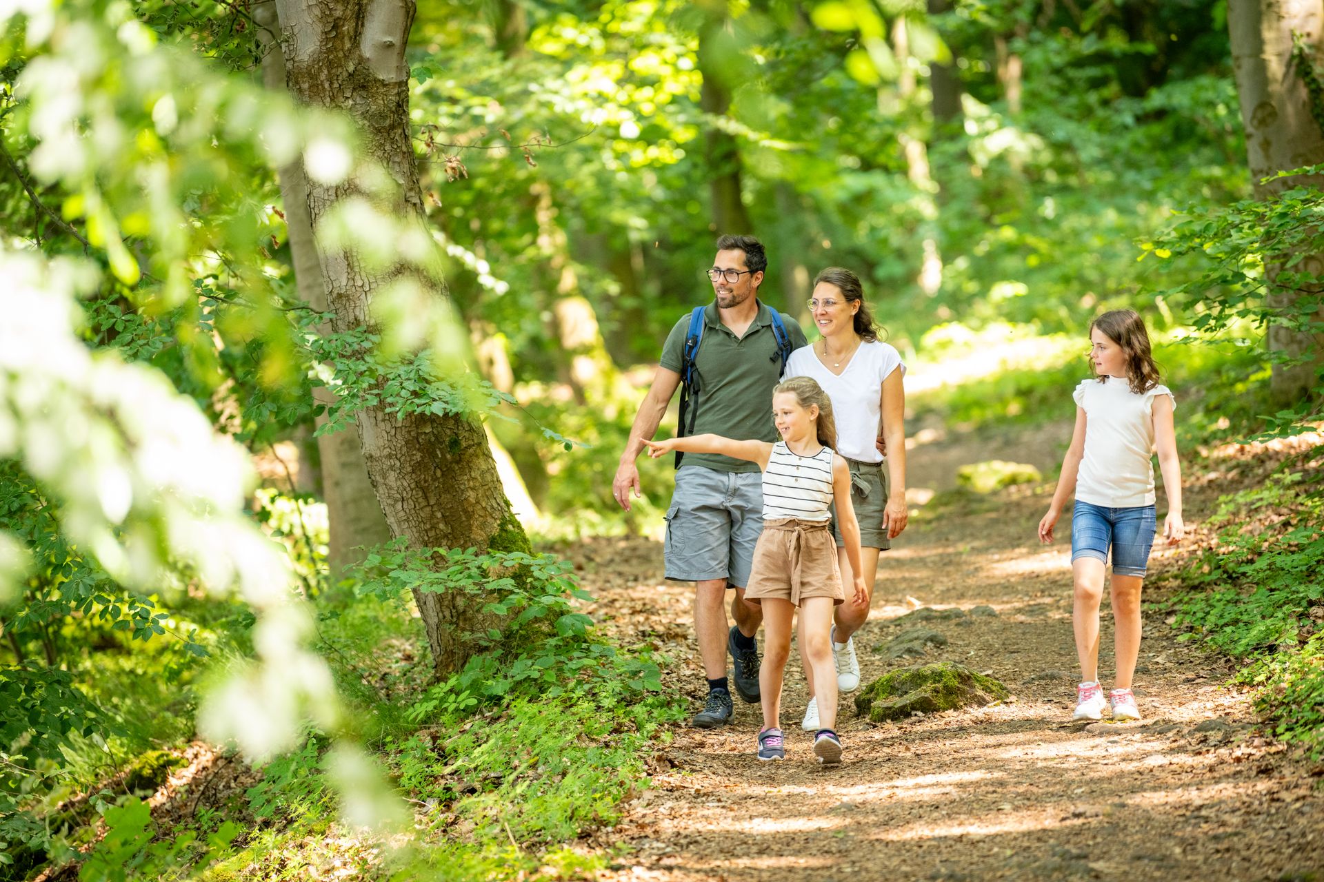 Eine Familie wandert durch Wald am Laacher See
