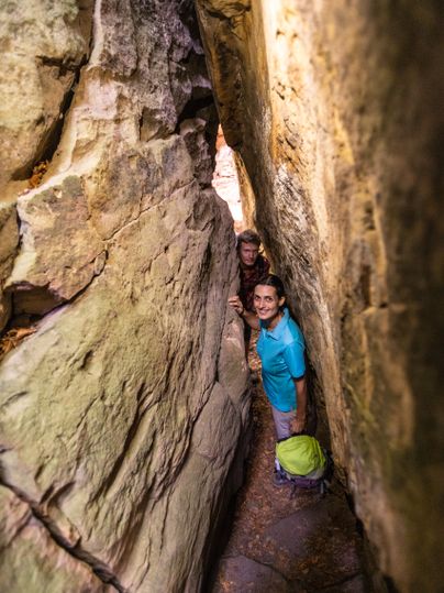 Twee mensen in een smalle rotsachtige kloof in het NaturWanderPark delux.