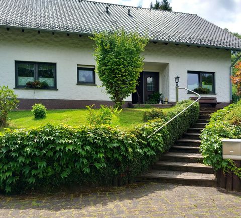 You reach the entrance area via an external staircase through a well-kept front garden with a pond.