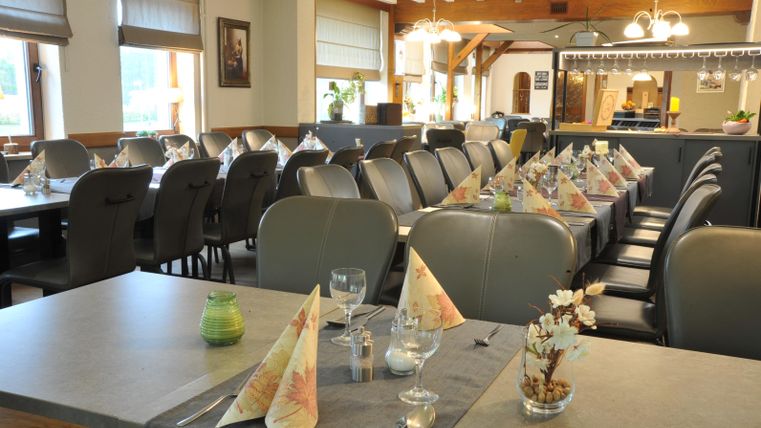 Ein gemütliches Restaurant mit gedeckten Tischen und stilvollen Servietten. Die Atmosphäre ist einladend und freundlich.