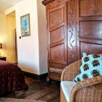 A cozy room with a wooden cupboard and a wicker chair. It is warm and inviting with a rustic charm.