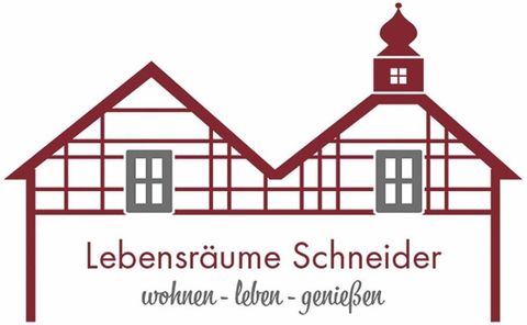 A logo with two stylized half-timbered houses. Below it, it says "Lebensräume Schneider" with the slogan "living - enjoying - savoring".