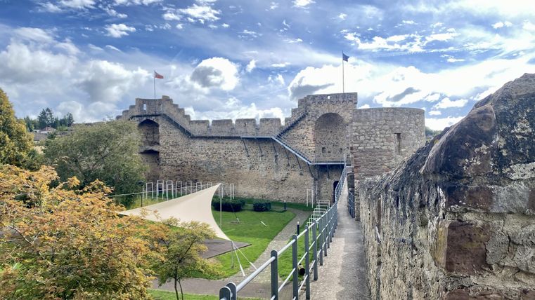 Walkable high stone city wall in Hillesheim with adjacent park area.