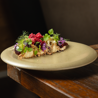 An artistically arranged plate with various herbs and berries. The dish looks fresh and inviting.