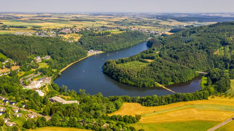 Luchtfoto van het stuwmeer van Biersdorf omringd door bossen en velden.