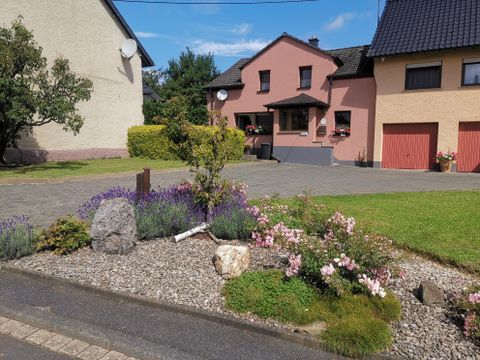 A beautiful residence with a well-maintained garden. Colorful flowers and shrubs are arranged around the entrance.