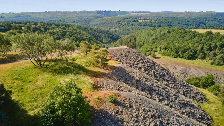 Blick auf Schieferberge umgeben von grünem Wald.