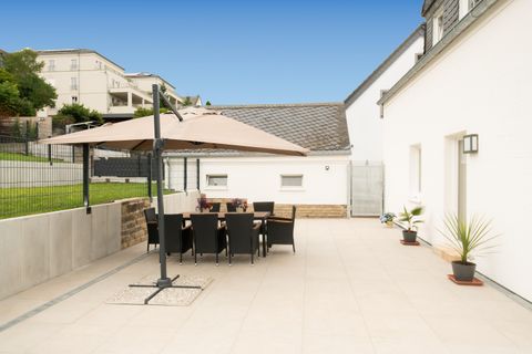 The 66 sqm large south sun terrace with seating group and sun umbrella.
