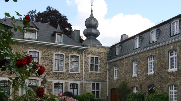 Bâtiment historique avec un dôme à bulbes et des fleurs au premier plan.