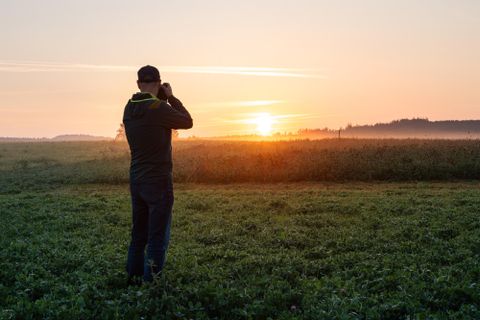 Photographe photographie le coucher de soleil.