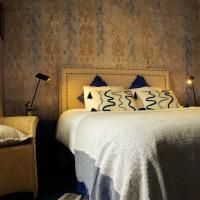 A cozy bedroom with a large bed and decorative pillows. The walls have a stylish texture, and the lighting creates a warm atmosphere.