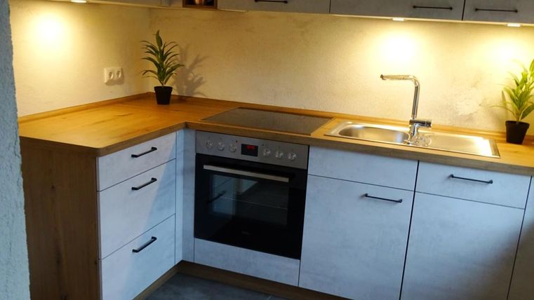 Küche mit Kühlschrank, Backofen, Elektro Herd und Spülmaschine