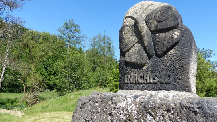 A stone sculpture of a butterfly with the inscription "Inachis io"