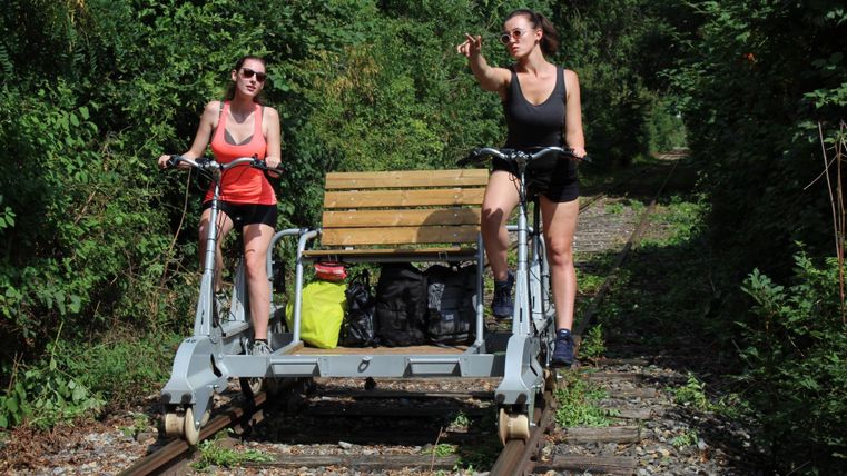 Frauen in sommerlicher Kleidung sind unterwegs auf einer Draisine