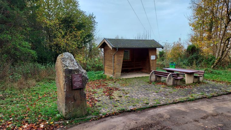 Wandelparkeerplaats met afdak en picknicktafel in de herfst.