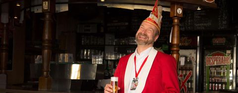 Lachender Herr Weininger mit einem Glas Kölsch in der Hand