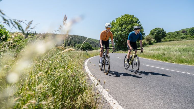 Two cyclists on a country road in the Eifel.