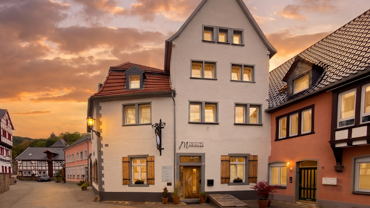 Un bâtiment charmant et historique dans une rue pittoresque. En arrière-plan, le ciel brille de couleurs chaudes au coucher du soleil.