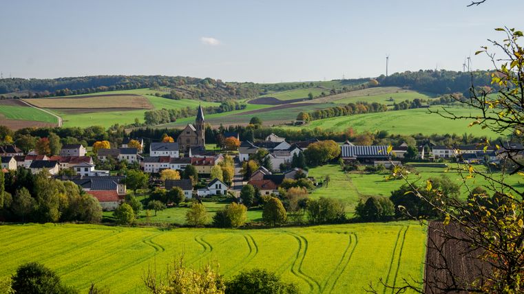 Vue panoramique sur le village d'Alsdorf avec son église et les champs environnants.