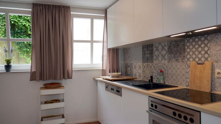 A bright kitchen with modern furniture and a large countertop.