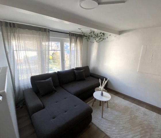 Wohnbereich mit gemütlicher Couch, © Ferienhaus Eifelzeit