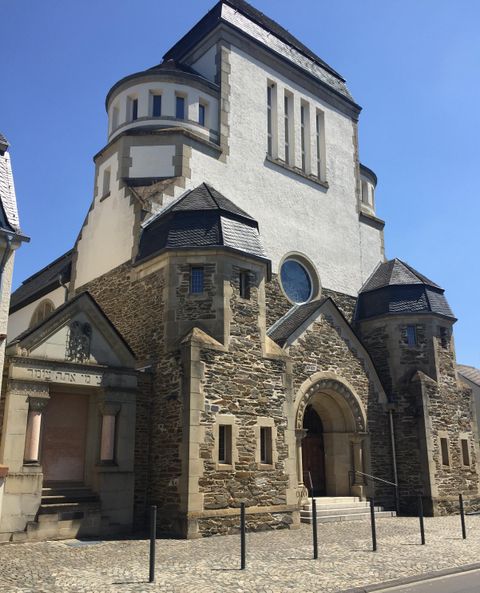 Une église historique avec une façade marquante et un beau toit. Le ciel est clair et bleu.