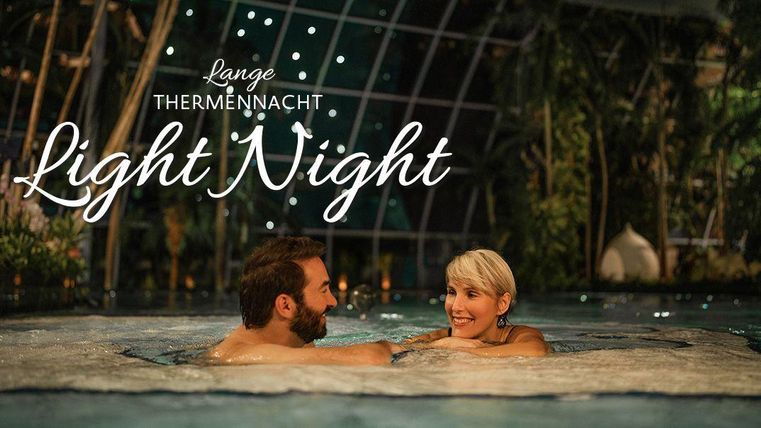 Two people in the pool at night