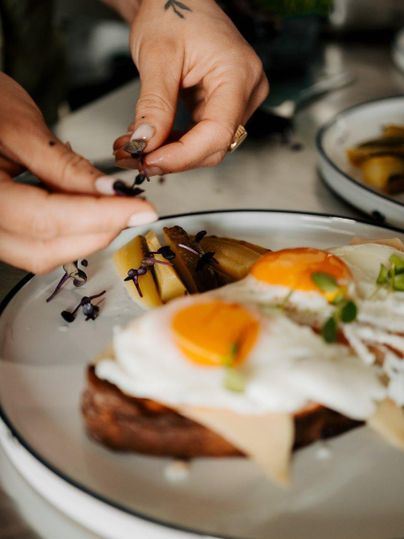 Een heerlijk ontbijtgerecht met roerei en brood wordt liefdevol gepresenteerd. Verse kruiden en bijgerechten geven het bord een aantrekkelijke uitstraling.