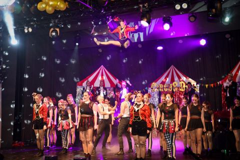 Twee vrouwen in kostuums hebben plezier. De een draagt een politieuniform, de ander een formele outfit.