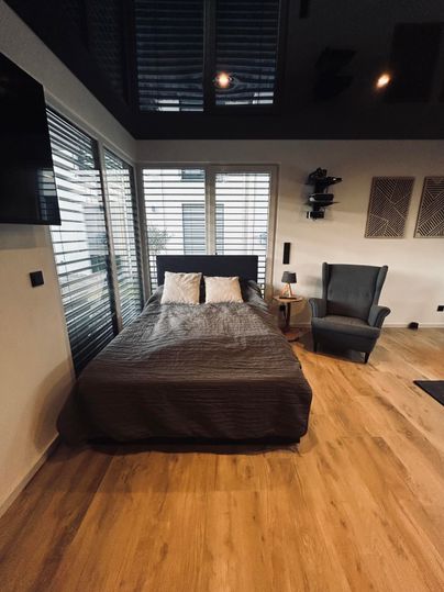 Double bed and a cozy seating area. Large windows provide plenty of natural light and an open space.