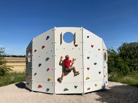 Ein Kind klettert an einer Kletterwand.