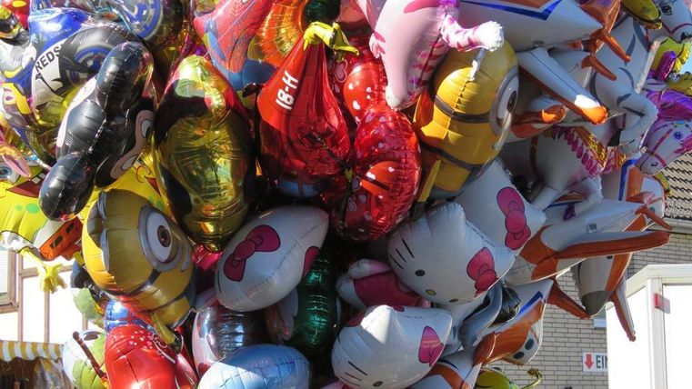 Eine bunte Ansammlung von Luftballons in verschiedenen Formen und Farben. Darunter sind mehrere Figuren wie Hello Kitty und Minions zu sehen.