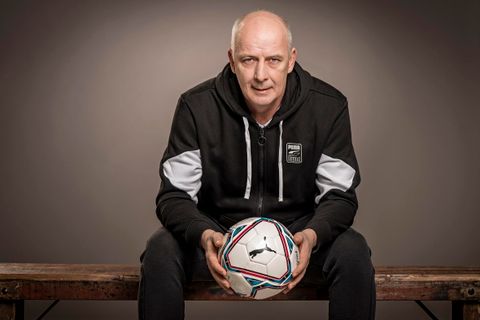Zittende man met een bal in zijn hand