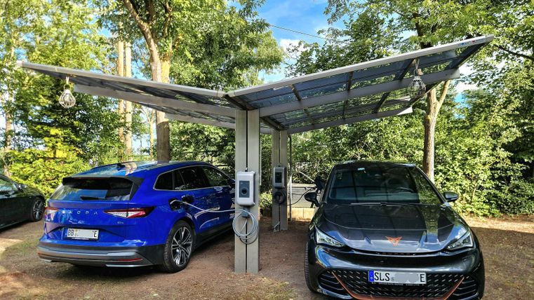 Twee elektrische auto's onder een carport. Twee oplaadpunten met elk 11 kW/h AC laadvermogen beschikbaar. Ontgrendeling en afrekening via de hotelreceptie. Reservering aanbevolen.