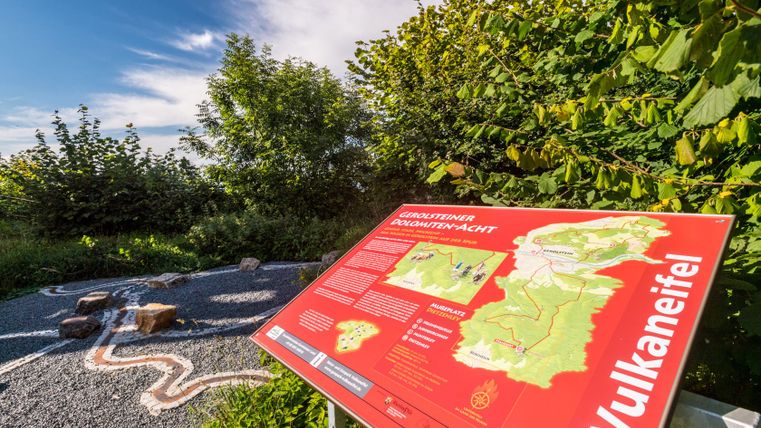 Panneau d'information à la Mußeplatz à Dietzenley dans le sentier celte, entouré d'arbres et d'un ciel dégagé.